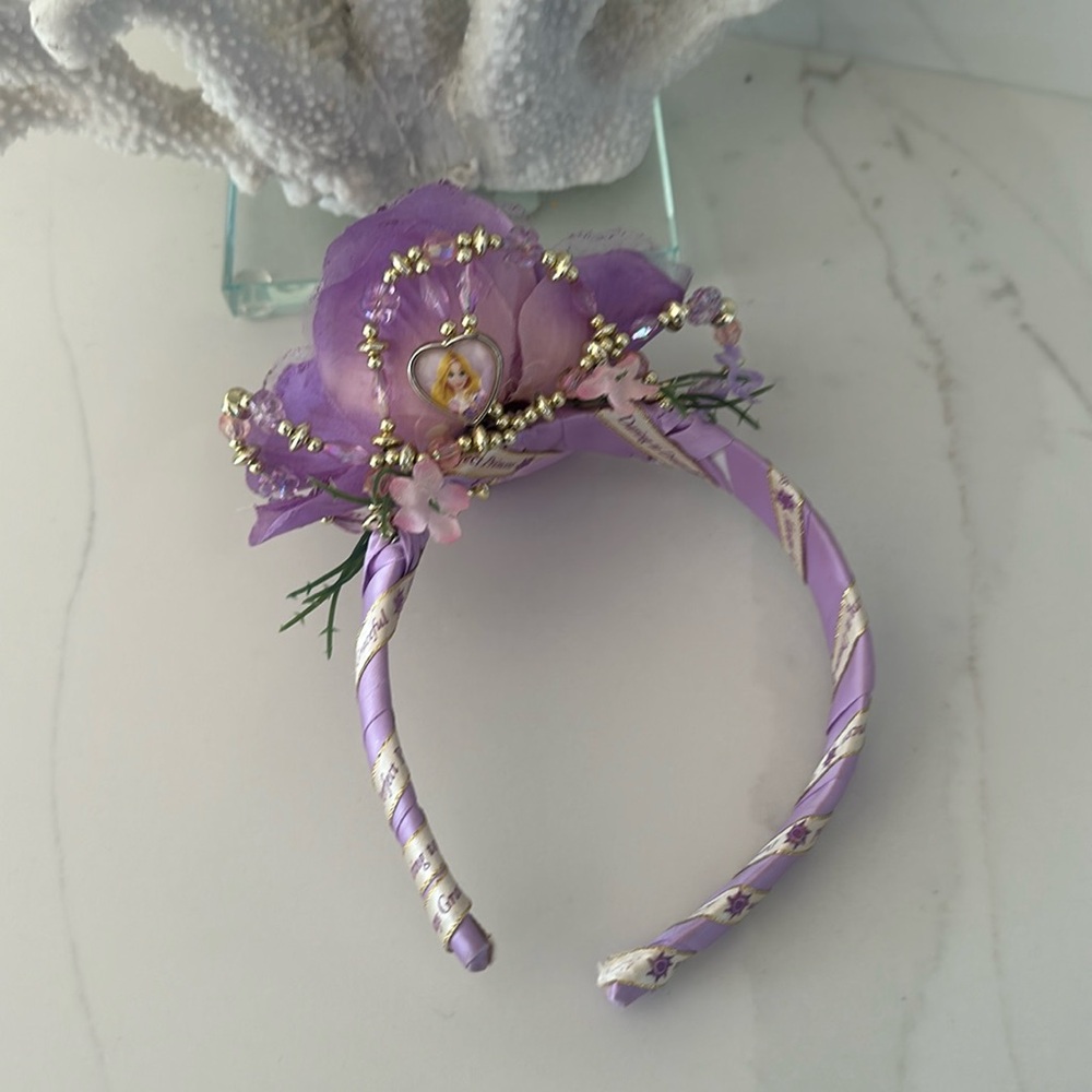 Disney Rapunzel headband. Color purple with flowers and heart of Rapunzel.